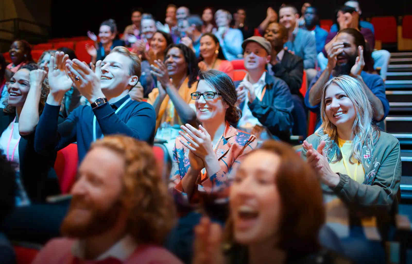 A crowd of people cheering during a presentation